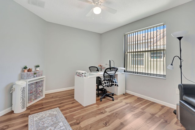 home office featuring a healthy amount of sunlight, light wood-type flooring, and ceiling fan