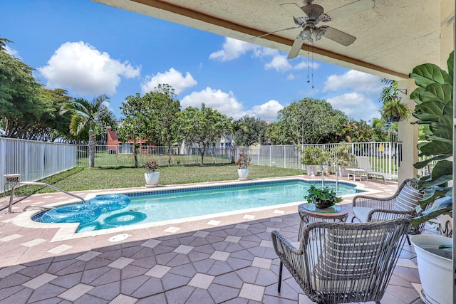 view of swimming pool with a patio area, a lawn, and ceiling fan