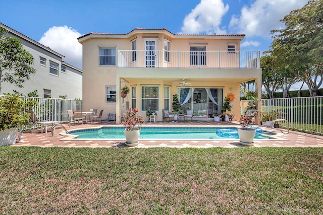 back of house with a patio area, a lawn, a balcony, and ceiling fan