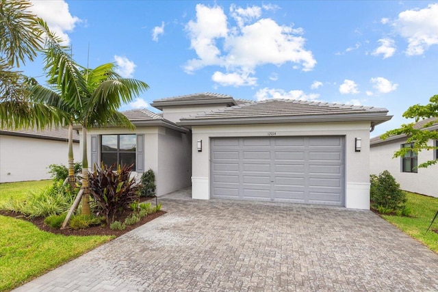 view of front of property featuring decorative driveway, an attached garage, and stucco siding