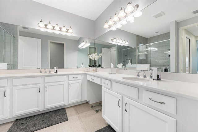 bathroom with tile patterned flooring, vanity, and walk in shower