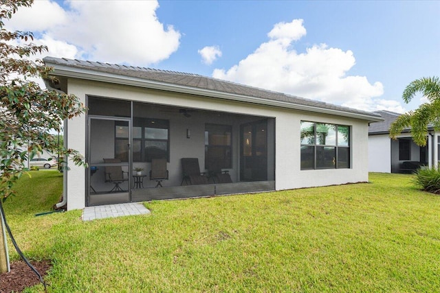 rear view of house featuring a sunroom and a yard