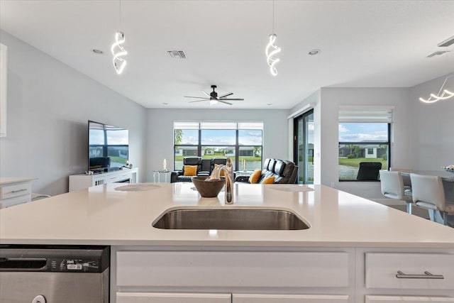 kitchen with white cabinets, a healthy amount of sunlight, sink, a center island with sink, and dishwasher