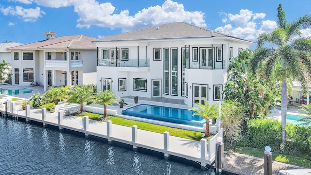 back of house with a water view, a patio, and a balcony