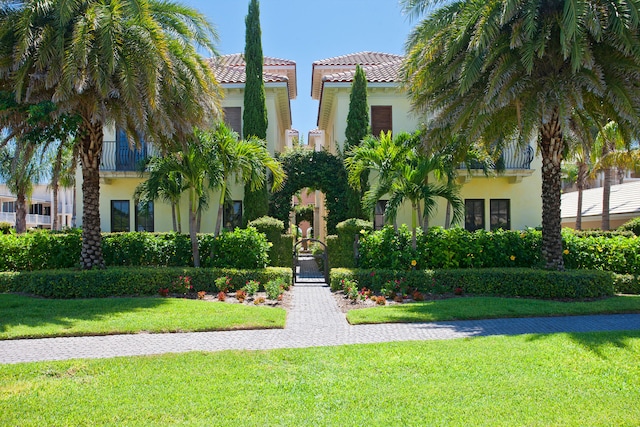 exterior space with a balcony and a front yard