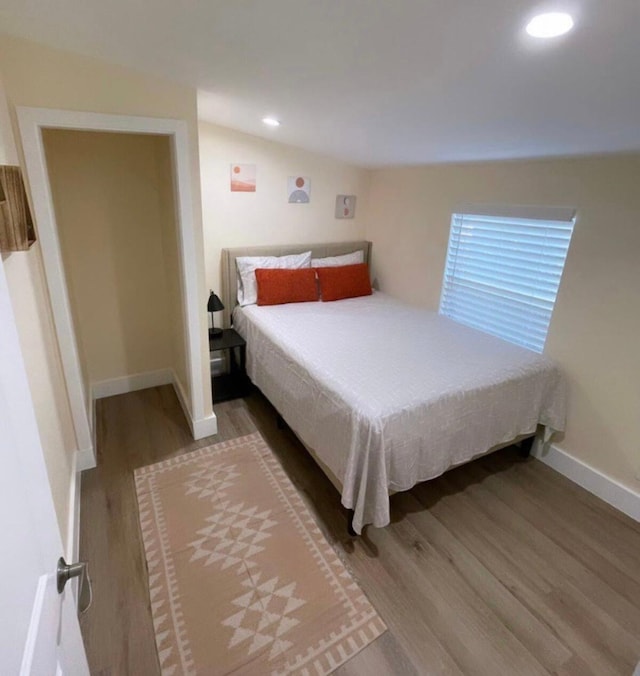 bedroom featuring vaulted ceiling and hardwood / wood-style floors