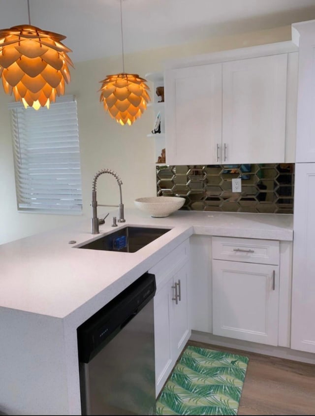 kitchen with white cabinets, dishwasher, hanging light fixtures, and sink