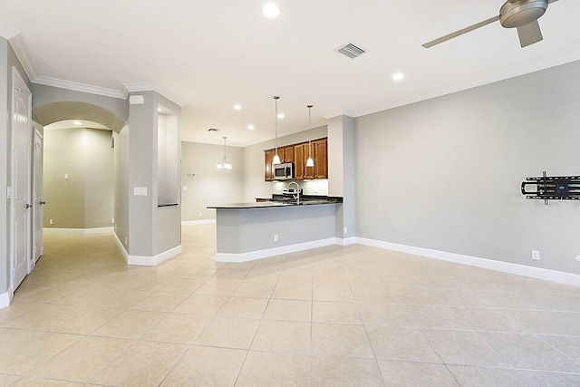 kitchen with sink, crown molding, appliances with stainless steel finishes, hanging light fixtures, and dark stone counters