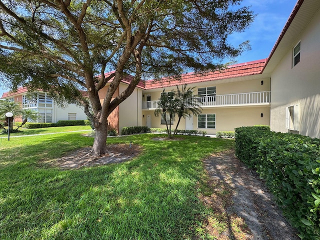 exterior space featuring a balcony and a front yard