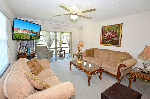 carpeted living room featuring ceiling fan and a textured ceiling