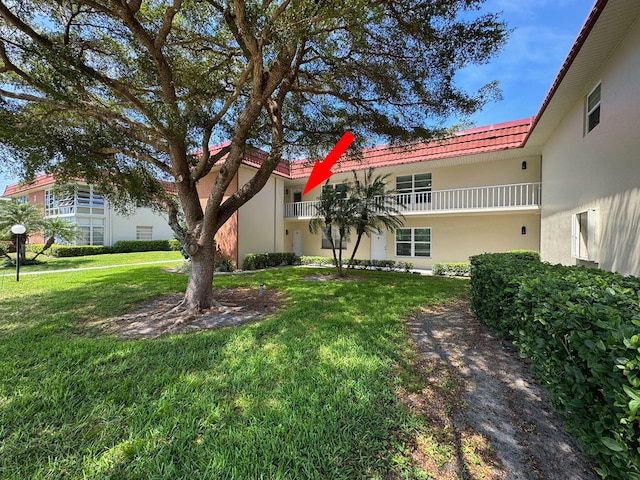 view of front of home featuring a balcony and a front yard