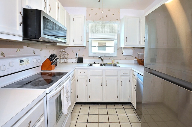 kitchen with stainless steel appliances, white cabinetry, and sink