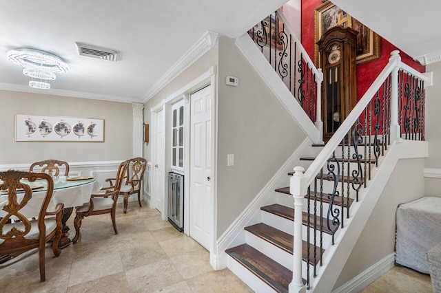 staircase with a chandelier and crown molding