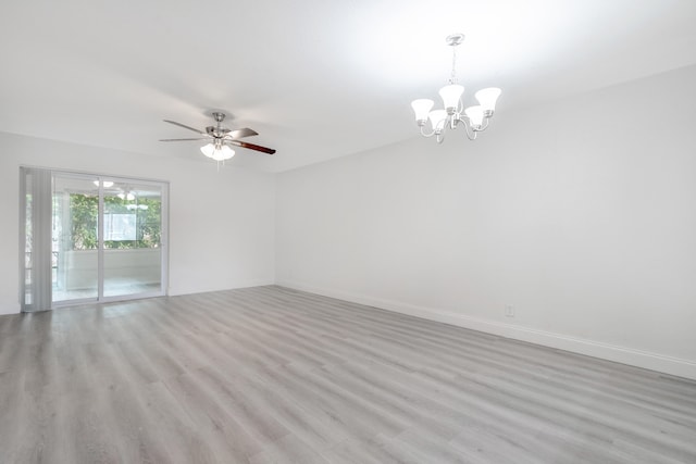 unfurnished room with ceiling fan with notable chandelier and light wood-type flooring