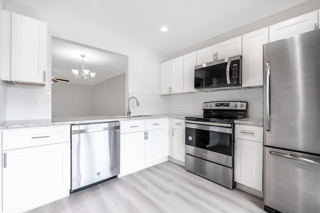 kitchen featuring sink, appliances with stainless steel finishes, light hardwood / wood-style floors, and white cabinetry