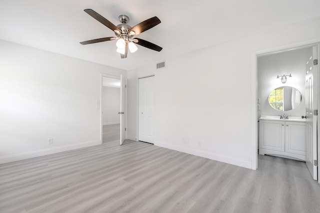 spare room with light wood-type flooring, sink, and ceiling fan