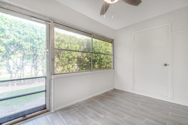 unfurnished sunroom featuring ceiling fan