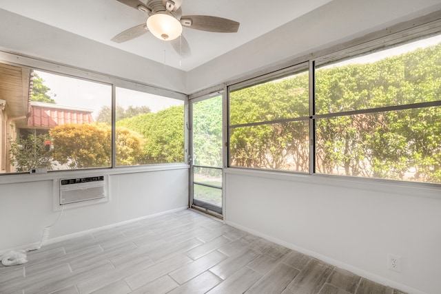 unfurnished sunroom featuring ceiling fan and a wall mounted AC