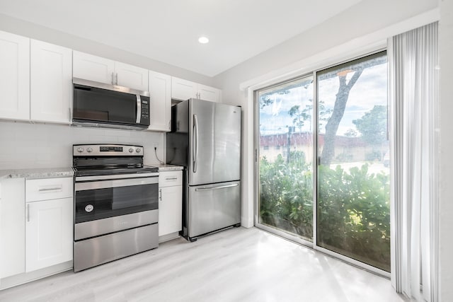 kitchen featuring decorative backsplash, white cabinetry, light hardwood / wood-style flooring, and stainless steel appliances