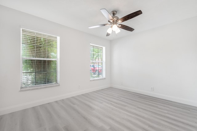 spare room with ceiling fan and light wood-type flooring