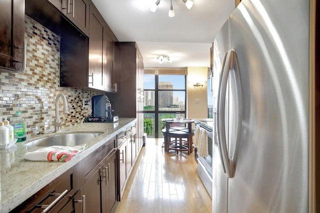 18181 NE 31st Ct Unit 1408, Aventura, FL 33160 - kitchen featuring tasteful backsplash, dark brown cabinets, a sink, light wood-style floors, and stainless steel appliances