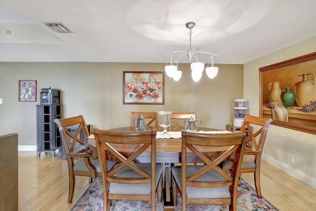 dining area with an inviting chandelier and light hardwood / wood-style flooring