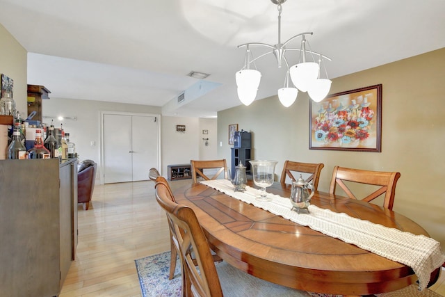 dining room with an inviting chandelier and light hardwood / wood-style flooring