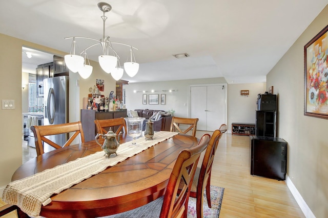 dining room featuring light wood-type flooring and a chandelier