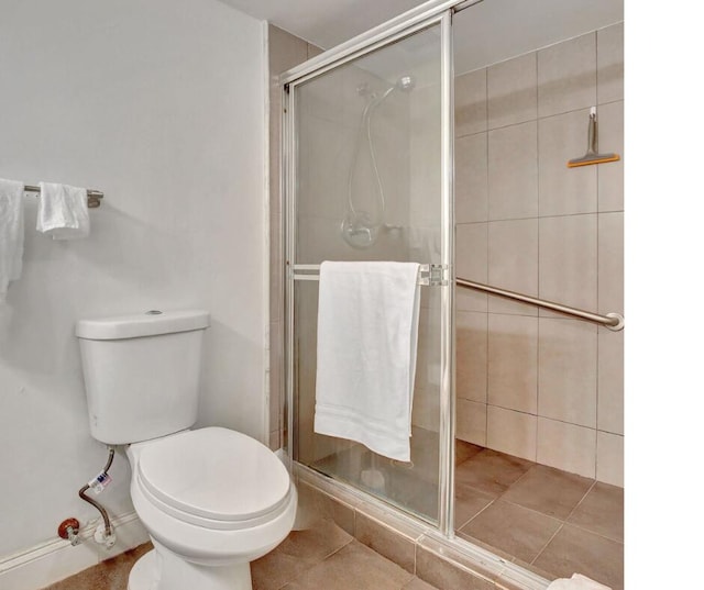 bathroom with an enclosed shower, tile patterned flooring, and toilet