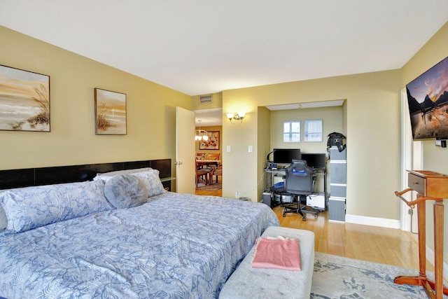 bedroom featuring a notable chandelier and light hardwood / wood-style flooring