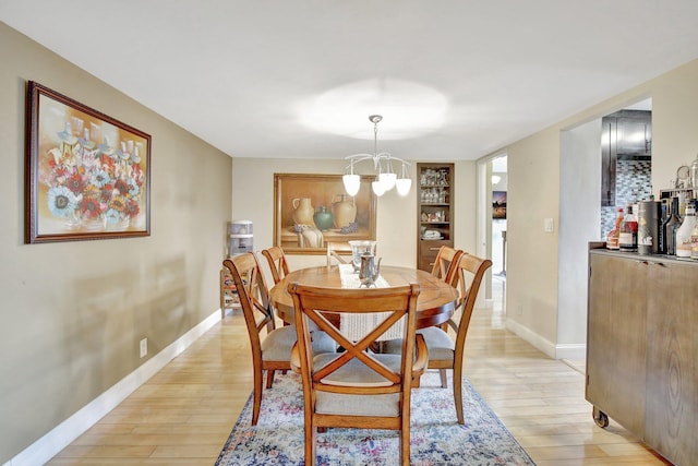 dining area with an inviting chandelier and light hardwood / wood-style floors