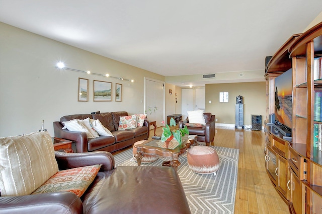 living room featuring light wood-type flooring and a healthy amount of sunlight