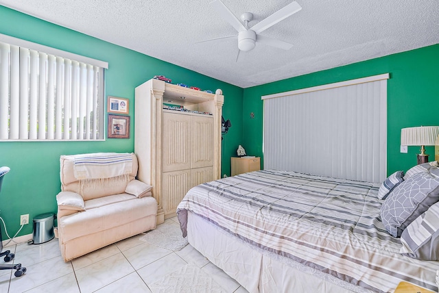 bedroom featuring ceiling fan, a textured ceiling, a closet, and light tile patterned flooring