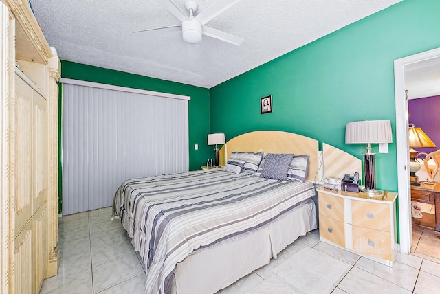 bedroom with ceiling fan, a textured ceiling, a closet, and light tile patterned floors