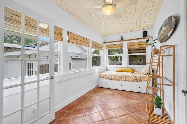 unfurnished sunroom with ceiling fan and wooden ceiling