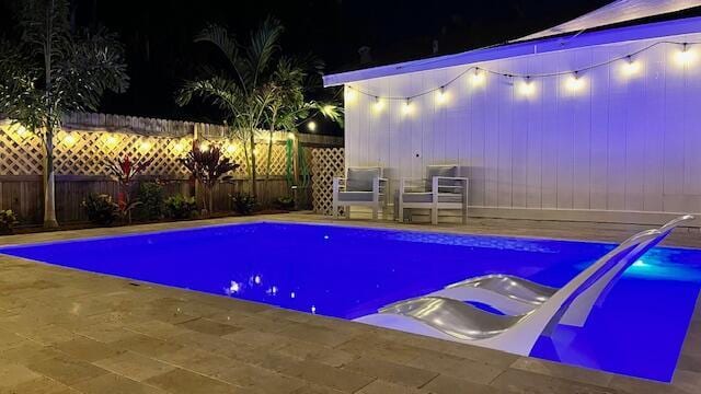 pool at twilight featuring a patio