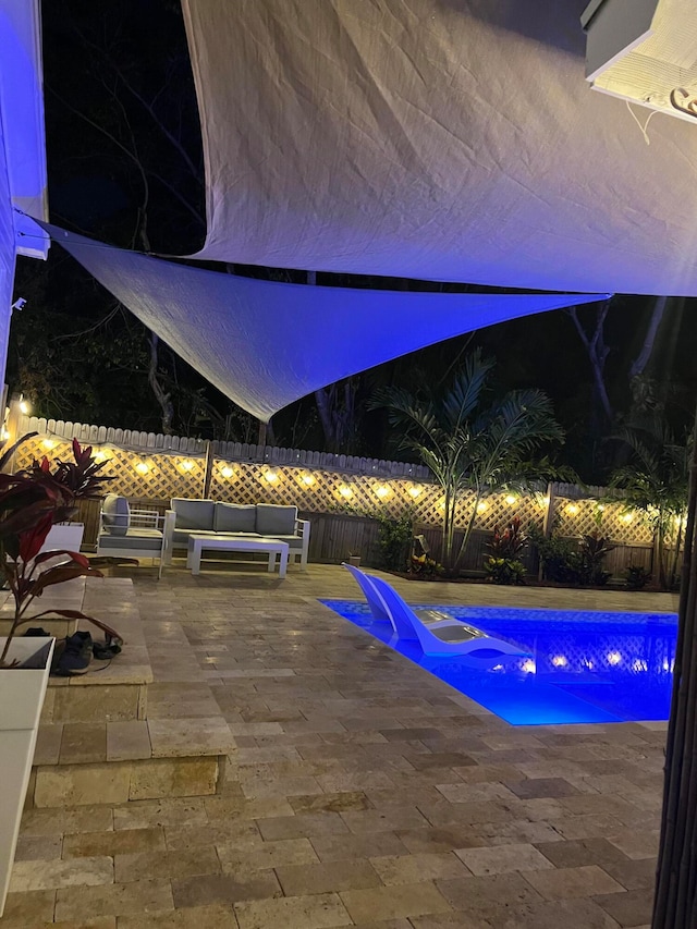 pool at twilight with an outdoor hangout area and a patio area