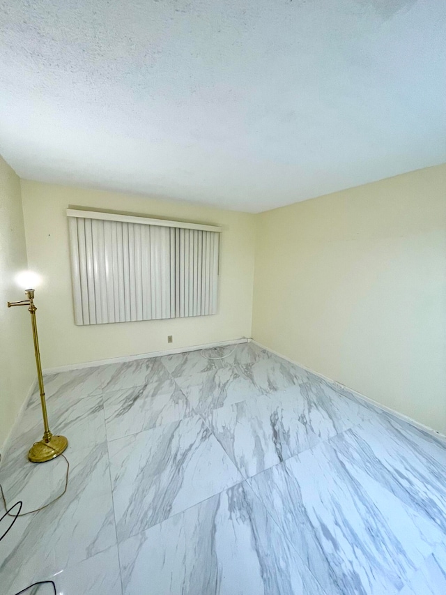 unfurnished room featuring a textured ceiling