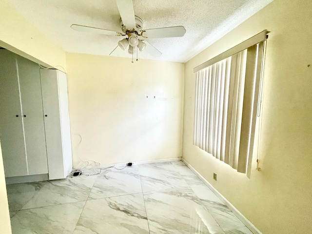 unfurnished room with a textured ceiling and ceiling fan