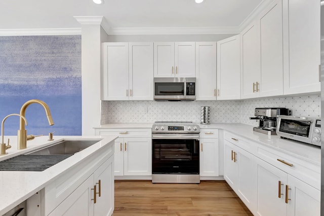 kitchen featuring crown molding, sink, white cabinets, and stainless steel appliances