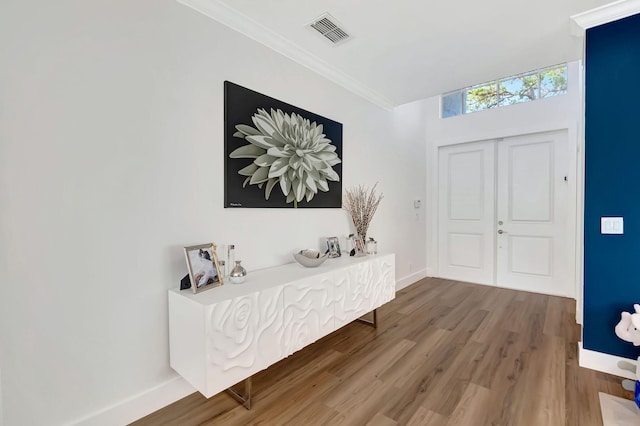 foyer featuring wood-type flooring and ornamental molding