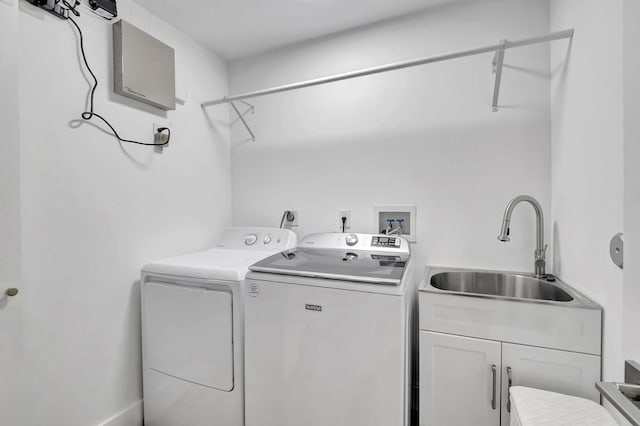 washroom featuring cabinets, independent washer and dryer, and sink