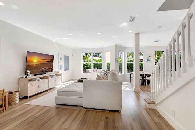 living room featuring crown molding and light wood-type flooring