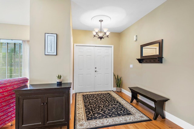 entrance foyer with a chandelier and wood-type flooring