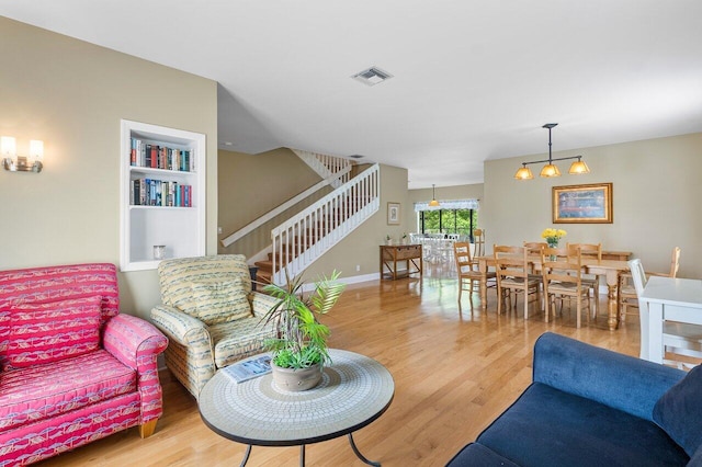 living room with hardwood / wood-style floors and a notable chandelier