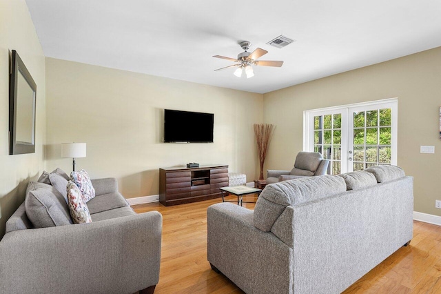 living room featuring french doors, ceiling fan, and light wood-type flooring