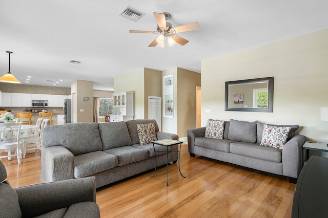 living room with light hardwood / wood-style floors and ceiling fan