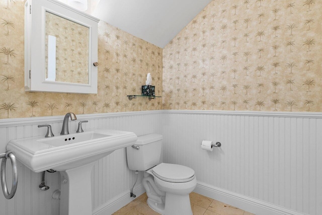 bathroom featuring lofted ceiling, sink, toilet, and tile patterned floors