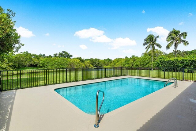 view of pool with a patio and a yard