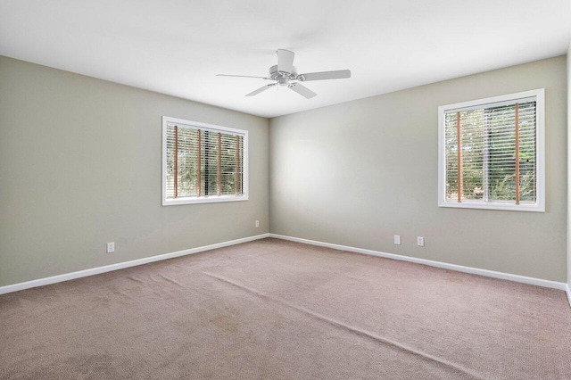 spare room with light colored carpet and ceiling fan